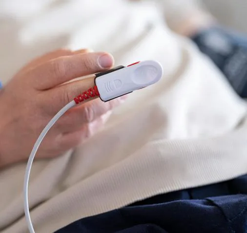 Close-up of a pulse oximeter sensor on a patient's finger